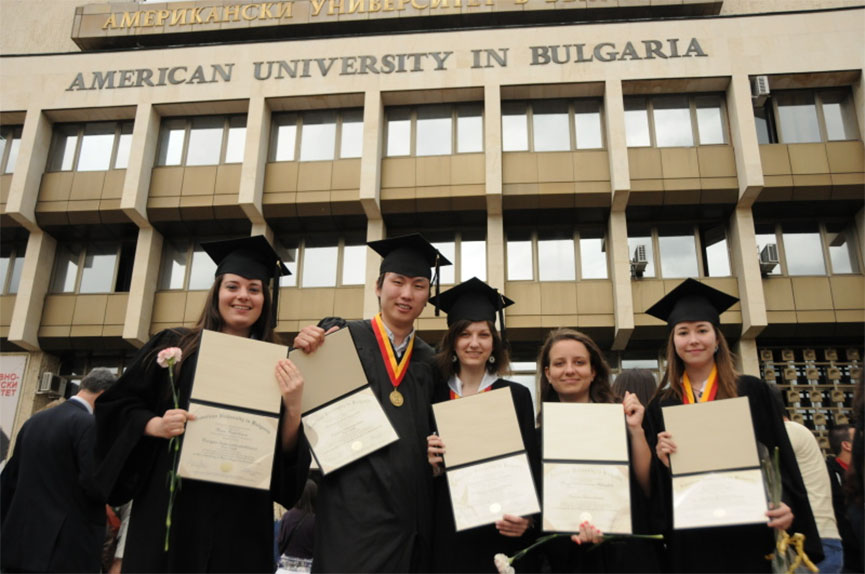 Радостные выпускники университета показывают свои дипломы