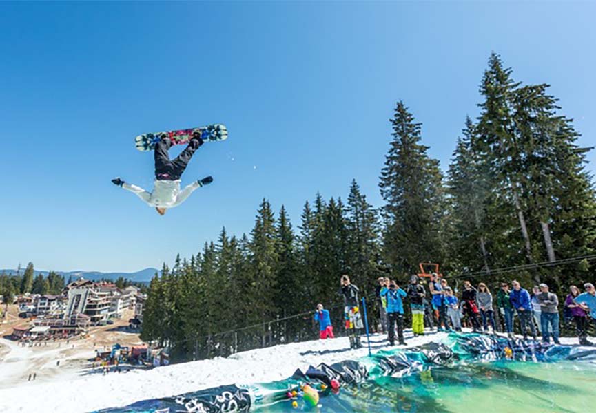 Сноубордист совершает прыжок да водой