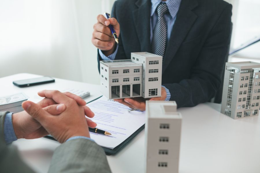 Мужчина выбирает между моделями домов, сравнивая рассрочку от застройщика и покупку на вторичном рынке Болгарии.